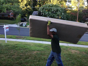 Junk removal carrying desk top into large truck get rid of it R